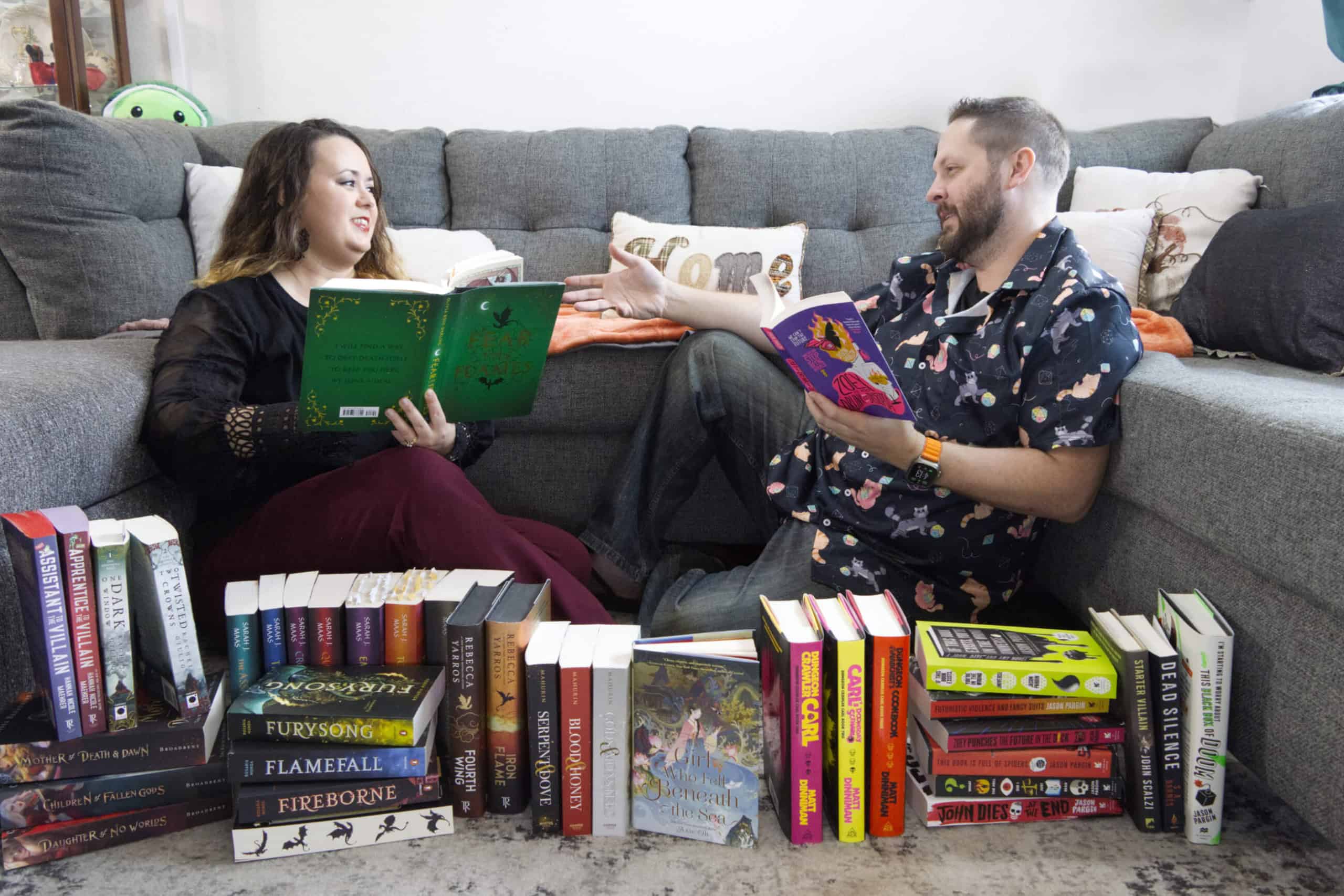 James & Ka-Ce sitting behind a pile of books